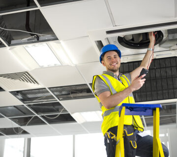 electrician fitting air conditioning to office interior